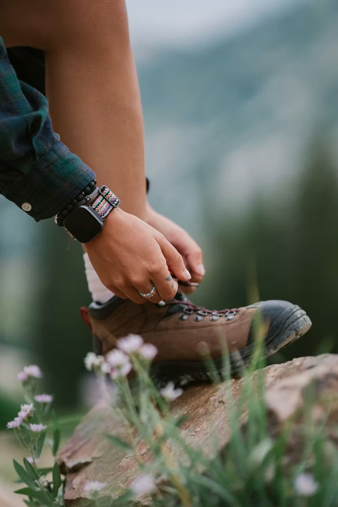 Hiker demonstrating how to tie hiking boots correctly before a trail hike