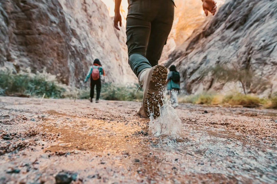 Applying waterproof spray to leather hiking boots before a hiking trip