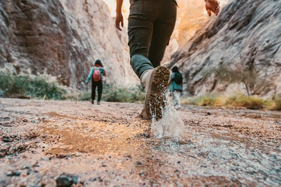 Applying waterproof spray to leather hiking boots before a hiking trip